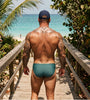 Man on a beach boardwalk in a sage Seaman Swim brief